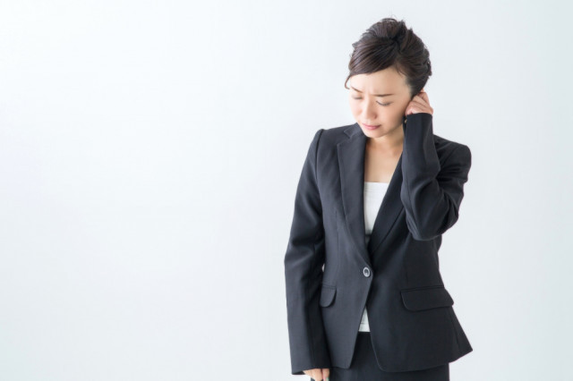 不調に悩む女性の写真